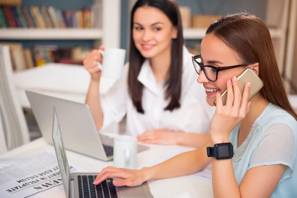 Colegas positivas sentadas a la mesa — Foto de Stock