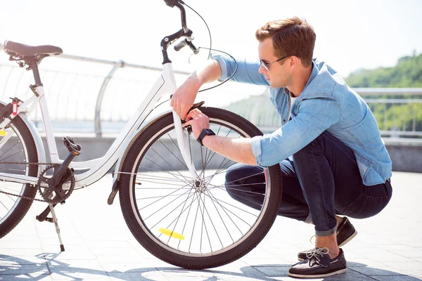Парень чинит колесо на велосипеде — стоковое фото