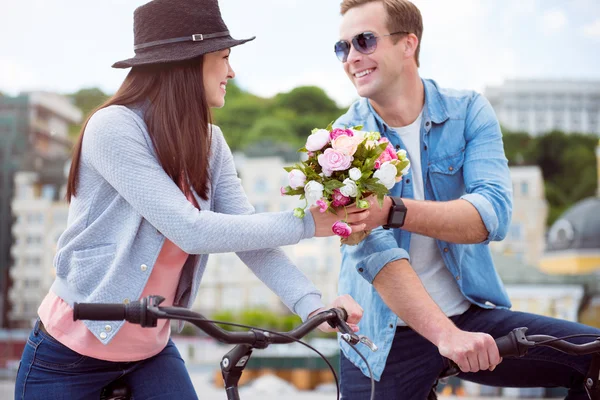 Hombre ofreciendo flores a mujer joven — Foto de Stock