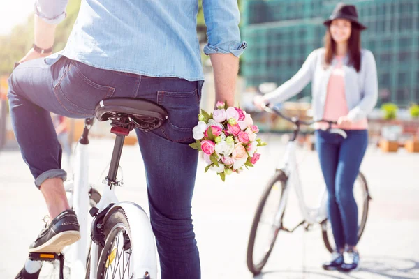 男の自転車に座っていると、花を持って — ストック写真