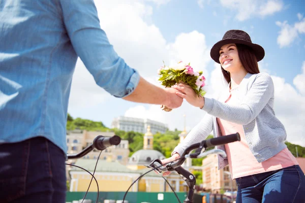 Man erbjuder blommor till kvinna i hatt — Stockfoto