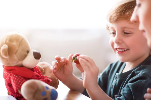 Kleiner Junge hält Erdbeere in der Hand — Stockfoto