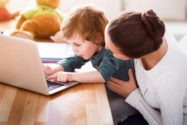 Mãe de ensino filho usando laptop — Fotografia de Stock