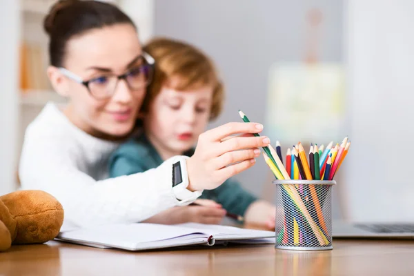 Mujer eligiendo un crayón en taza de lápiz — Foto de Stock