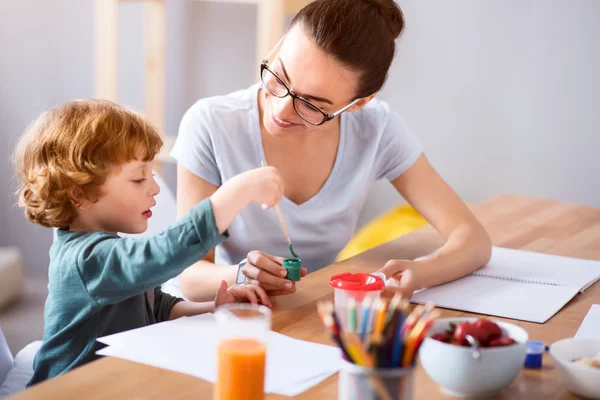 Kleiner Junge nimmt Farbe mit Pinsel — Stockfoto