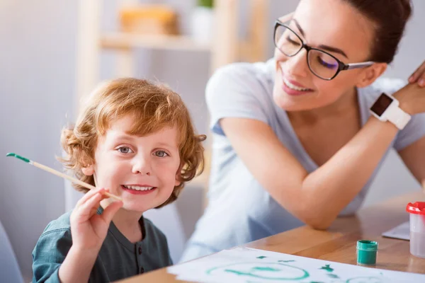 Pojken håller penseln och tittar på kameran — Stockfoto