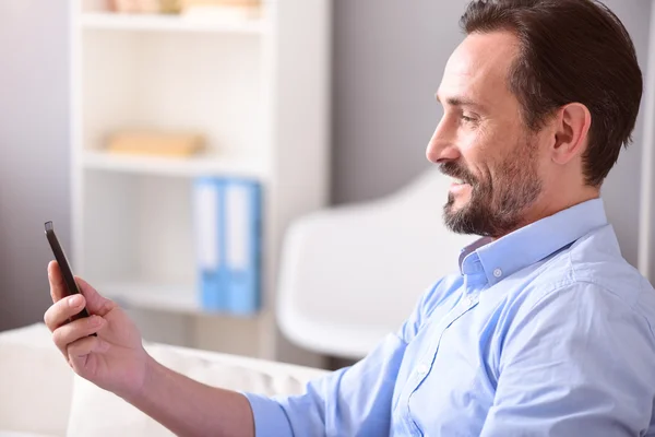 Homme souriant regardant son téléphone — Photo