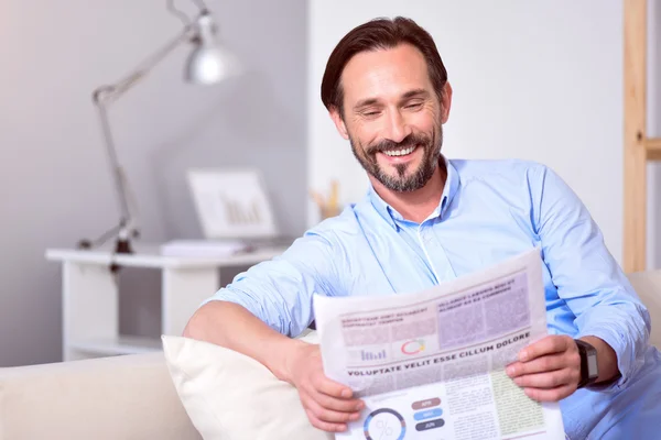 Homme lisant le journal sur le canapé — Photo