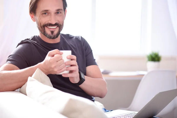 Hombre sosteniendo la taza y mirando a la cámara — Foto de Stock