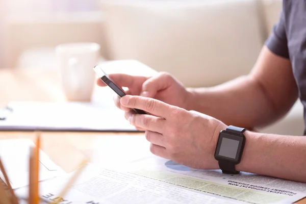 Man holding a phone on the table — Stock Photo, Image