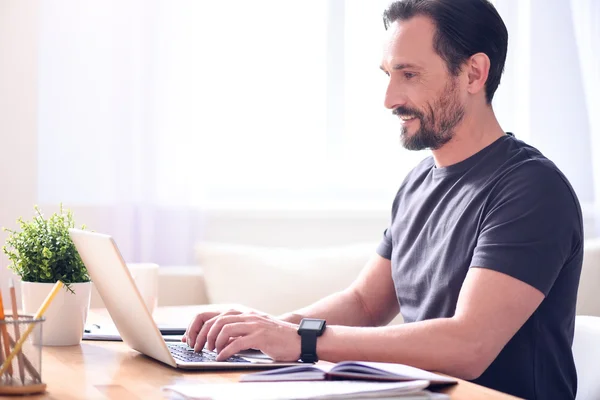 Gelukkig volwassen man die op zijn laptop werkt — Stockfoto