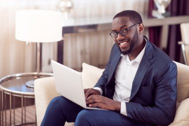 adam kameraya bakarak dizüstü bilgisayar ile