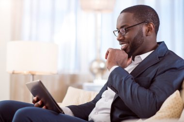 tablet kullanarak takım elbiseli adam