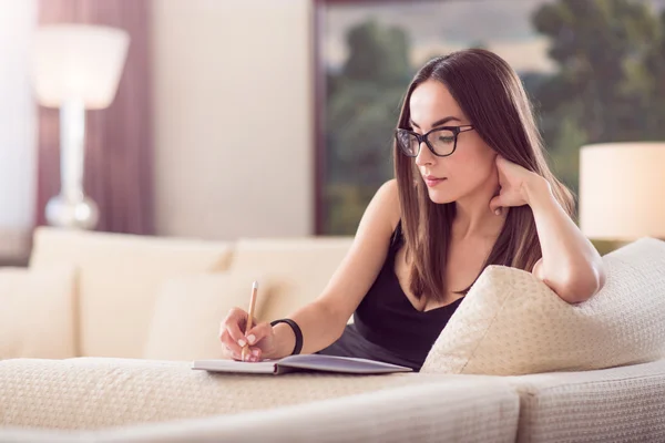 Frau schreibt ins Notizbuch — Stockfoto