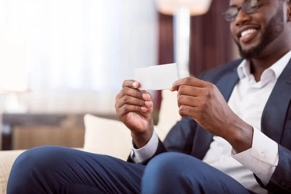 Hombre afroamericano sosteniendo tarjeta de bajeza en blanco — Foto de Stock