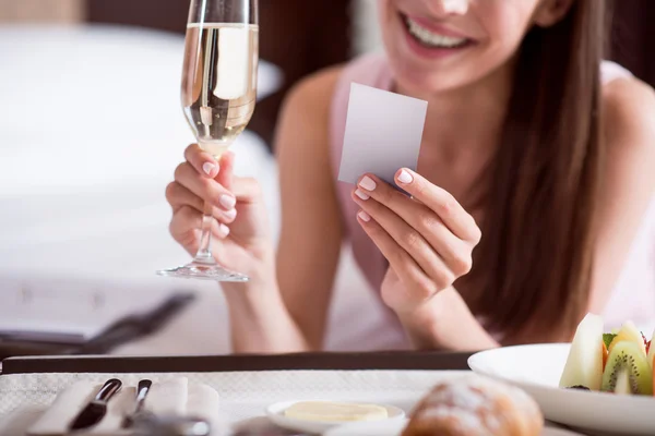 Vrouw op zoek op de kaart en houden van champagne — Stockfoto