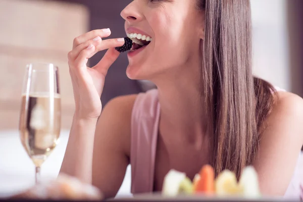 Vrouw zetten berry in mond — Stockfoto