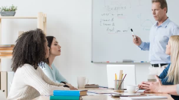 Profesora agradable teniendo una lección con estudiantes universitarios — Vídeos de Stock