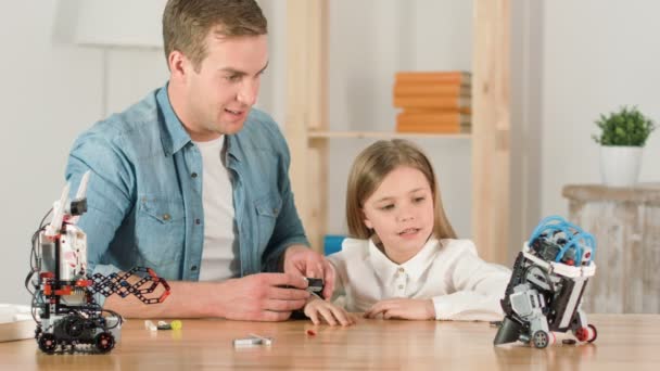Веселый отец и его дочь играют с игрушкой-роботом — стоковое видео
