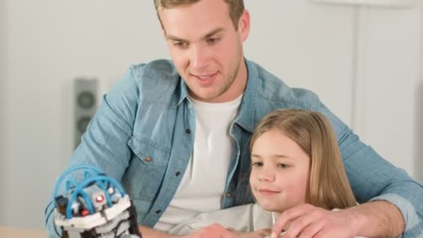 Père joyeux et sa fille jouant avec le jouet robot — Video