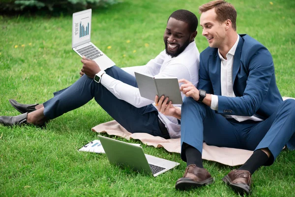 Compañeros alegres sentados en la hierba — Foto de Stock