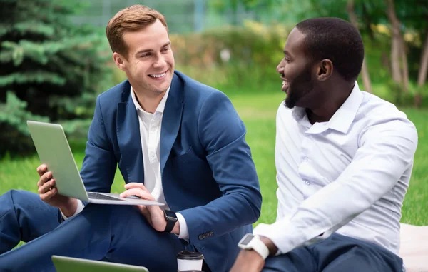 Positiva kollegor som sitter på gräset — Stockfoto