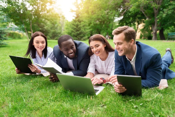 Positiva kollegor som sitter på gräset — Stockfoto