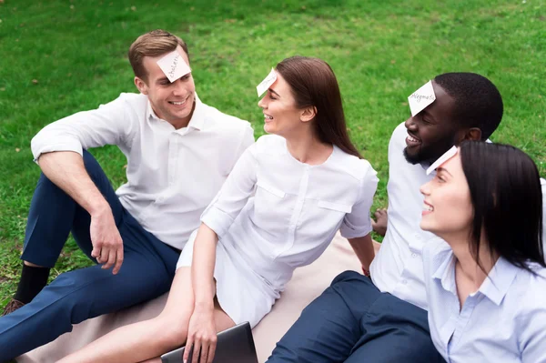 Alegres amigos sonrientes descansando sobre la manta — Foto de Stock