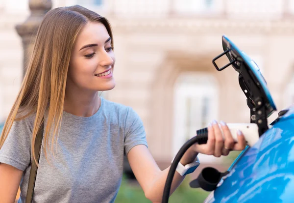 Mujer cargando batería de coche ecológico — Foto de Stock