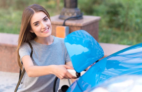 Frau lädt Batterie von Hybridauto — Stockfoto