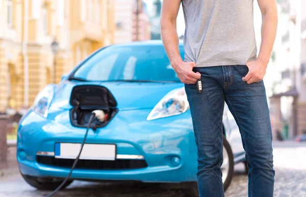 Homem em pé na frente do carro elétrico — Fotografia de Stock