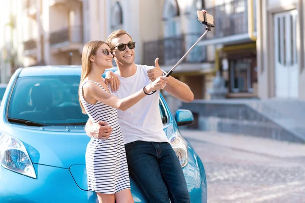 Hombre y mujer tomando selfie cerca de coche —  Fotos de Stock