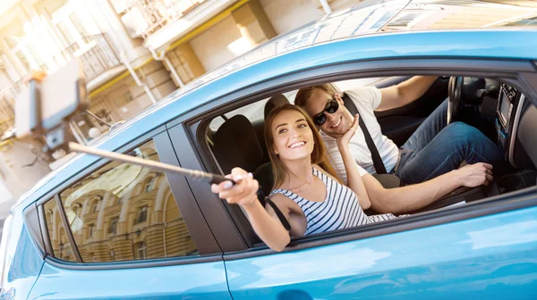 Man and woman taking selfie in car — Stock Photo, Image