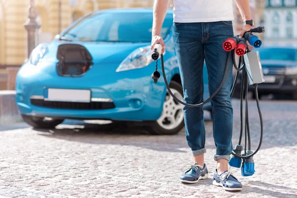 Hombre sosteniendo muchos cables de alimentación —  Fotos de Stock