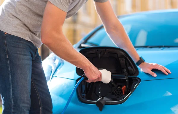 Man plugging cable in hybrid car — Stock Photo, Image