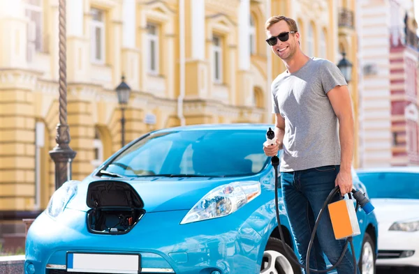 Man håller strömkabeln till hybridbil — Stockfoto