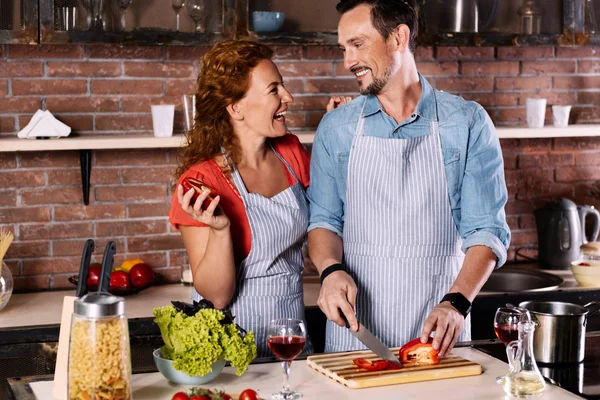 Mulher sorrindo para o homem na cozinha — Fotografia de Stock