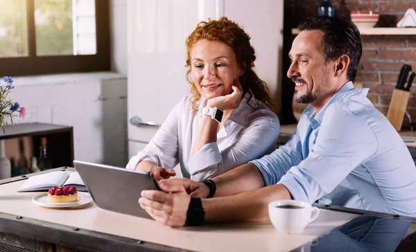 Paar schaut auf Tablet und spricht — Stockfoto