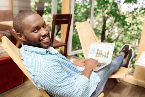 Hombre guapo positivo sentado en la silla — Foto de Stock