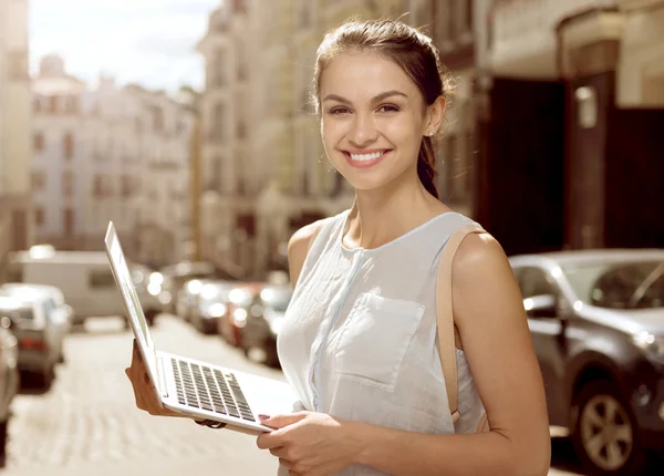 Mulher bonita alegre segurando laptop — Fotografia de Stock