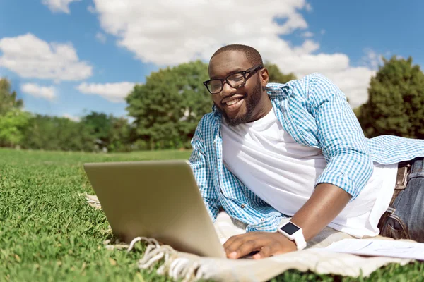 Dizüstü bilgisayar kullanan olumlu gülümseyen adam