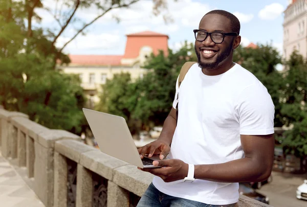 Hombre sonriente positivo usando el ordenador portátil — Foto de Stock