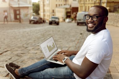 Sokakta oturan memnun gülümseyen adam