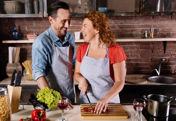 Hombre y mujer riendo mientras cocinan — Foto de Stock