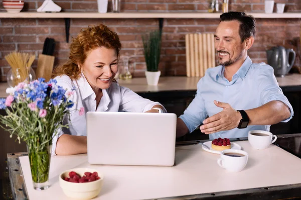 Casal olhando para laptop enquanto toma café da manhã — Fotografia de Stock