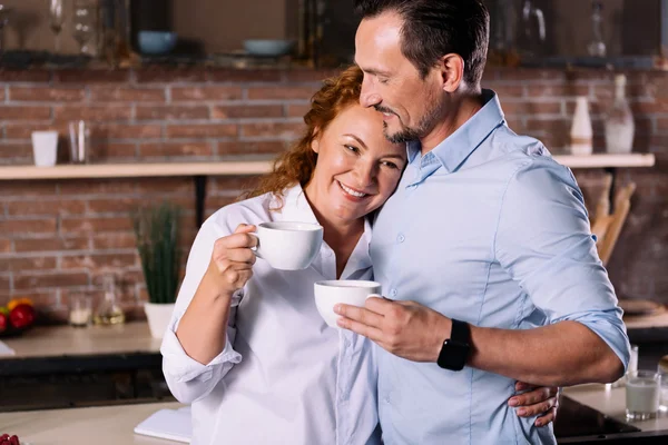 Mujer y hombre abrazándose mientras bebe café — Foto de Stock