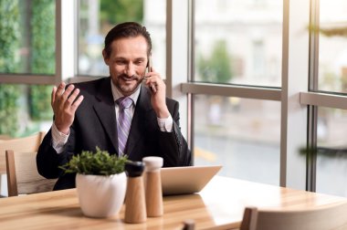 Cep telefonuyla konuşan neşeli gülümseyen adam