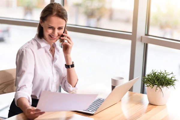 Agradable mujer encantada sentada a la mesa — Foto de Stock