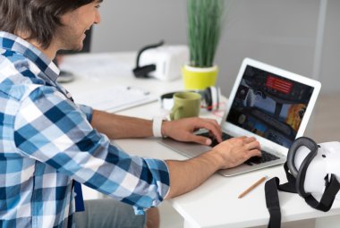 Bilgisayar oyunları oynayan neşeli gülümseyen adam