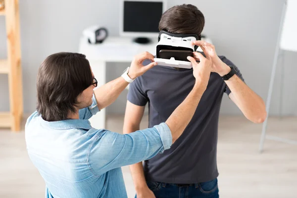 Colegas agradáveis testando óculos de realidade virtual — Fotografia de Stock